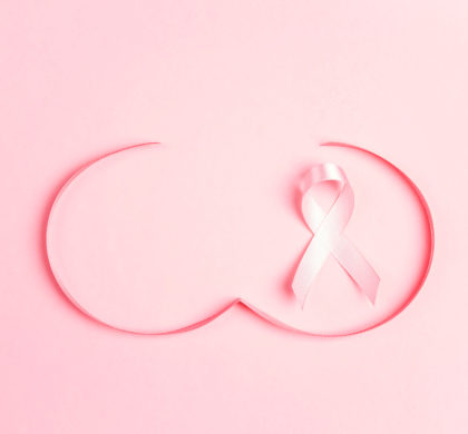Pink ribbon with breast shape symbol on pink background.  Breast cancer awareness symbol. October awareness month campaign.