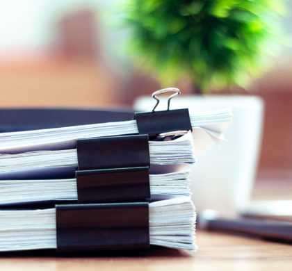 Stack of documents placed on a business desk in a business office.